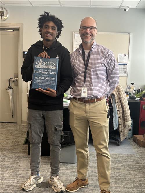 Keyshaun Johnson, Erie High's Stairclimber recipient for the month of January, poses with his plaque and Principal Orlando.